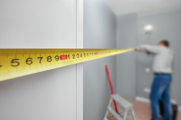 Man with tape-line measuring distance