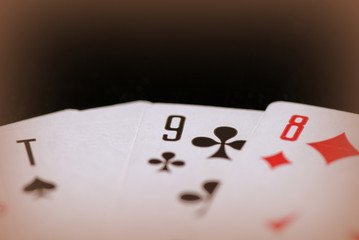 Playing cards on a dark background close up. Retro style toned