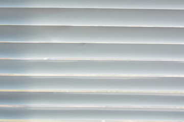 Aluminum texture in stripes as background surface with natural pattern for design and decoration. View white closed blinds.