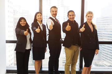 Group of diverse professional business people standing giving thumbs up and smiling in the office for successful work and good teamwork. People working in multinational company and cooperation concept