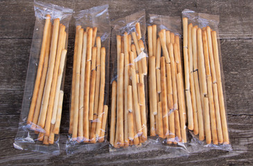 Tasty Italian bread sticks on wooden background
