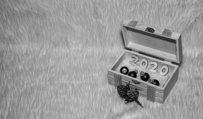 Imagen Navideña con un cofre de madera con el numero del año nuevo 2020 y 4 bolas de navidad en blanco y negro