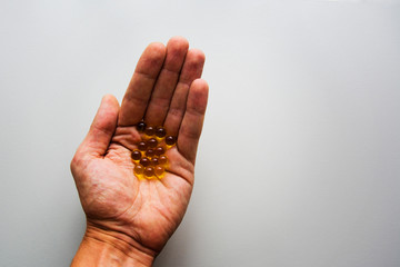 Healthcare, treatment, supplements concept photo. Man arm holding heap of small round meds.