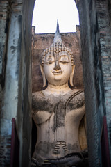 The ancient grand stucco Buddha in the chamber in the old historical park in Sukhothai province , Thailand. 