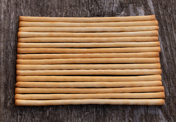 Tasty Italian bread sticks on wooden background