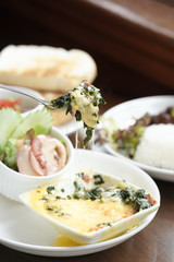 Spinach cheese. Selective focus with spinach cheese on the fork and blurred toast bread on the background.