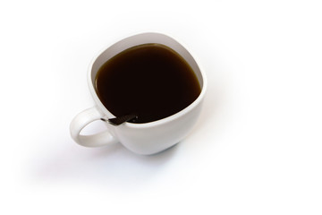 White cup of coffee with a spoon on an isolated background. Black cappuccino drink in a bowl