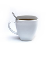 White cup of coffee with a spoon on an isolated background. Black cappuccino drink in a bowl