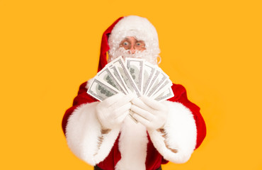 Happy Santa win a lottery and holding dollar money on orange