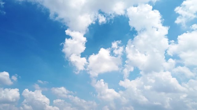 White puffy clouds and blue sky time-lapse with long second duration for background and graphics in daylight.