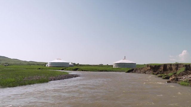 Static Shot Of Yurts Alongside Rushing River In Mongolia Countryside