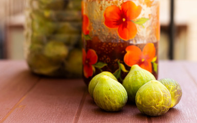 fresh green figs on plastic bottle and jam jar outdoor, organic food concept © hadjanebia