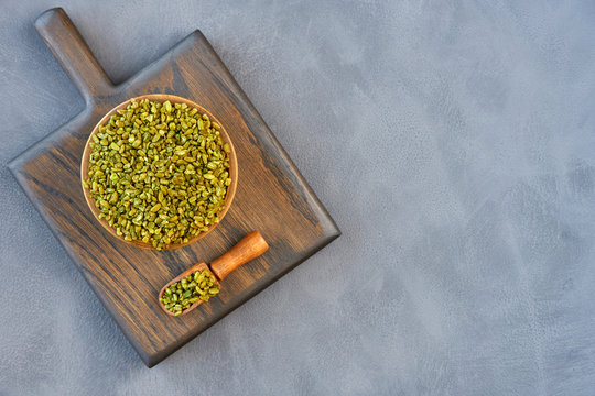 Uncooked cracked freekeh grain in wooden bowl. Top view with space for text	