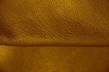 Natural leather texture. Brown background. Golden skin. Yellow shade of material.