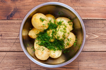 young raw potatoes with herbs for baking in the oven, top view, selective focus