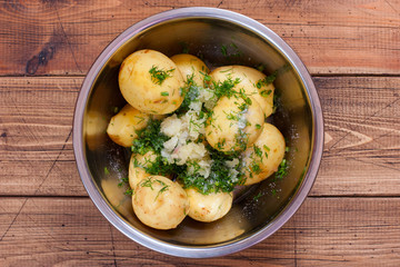young raw potatoes with herbs for baking in the oven, top view, selective focus