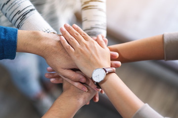 Top view image of people putting their hands in stack together