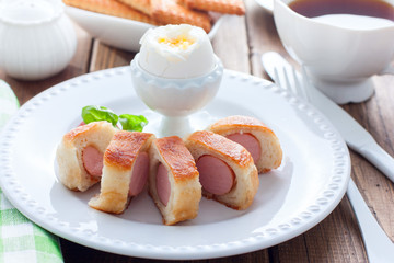 Breakfast with sausages in yeast dough on a wooden table, horizontal