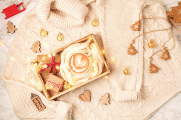Fototapeta na wymiar Top view over Christmas composition with warm sweater, gifts, xmas lights and coffee