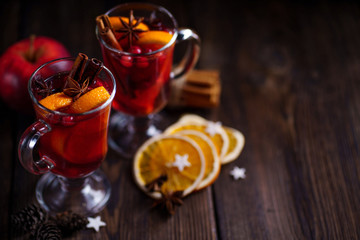 Mulled wine with aromatic spices and fruits on wooden rustic table, copy space. Traditional...