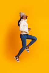 Active afro winter girl jogging in the air