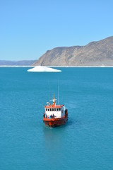 boat in the bay of the Eqip Sermia with icebergs  - melting Eqi Glacier in Greenland Disko Bay,  World of greenland travel - global warming and climate change. Summer, July © Friederike
