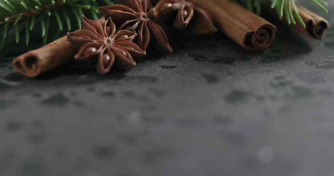 Tilt shot of spruce twig with cinnamon and anise on terrazzo countetop