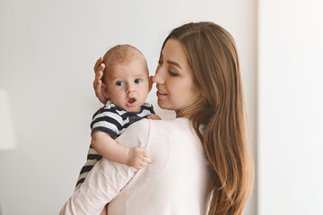 Portrait of young mother with adorable yawning baby