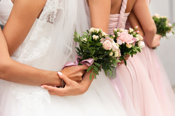 Bride and bridesmaids in pink dresses posing with bouquets at wedding day. Happy marriage and...