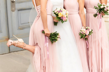 Bride and bridesmaids in pink dresses having fun at wedding day. Happy marriage and wedding party concept