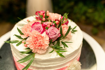 Wedding cake with natural flowers. Sweet and delicious dessert for wedding party. Marriage concept