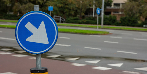Roadsign one way, blue and round, white color arrow direction right