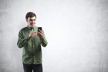 Smiling young casual man using smartphone, mock up