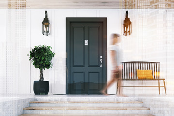 Woman passing by black door of white house