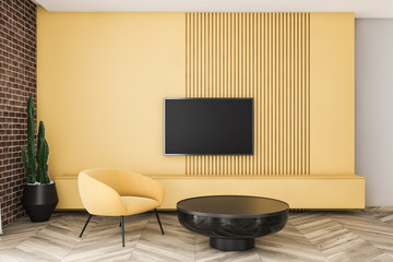 Brick and yellow living room with armchair and TV
