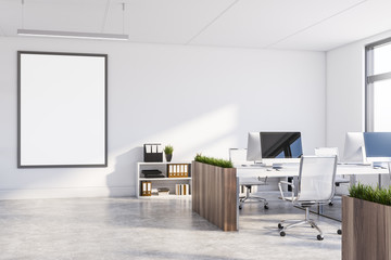 White office with dark wooden tables and poster
