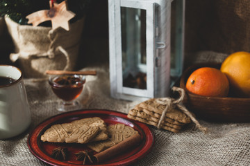 speculoos Christmas cookies on a red plate with star anise, honey and cinnamon, the effect of the film and tinting, soft focus and bokeh