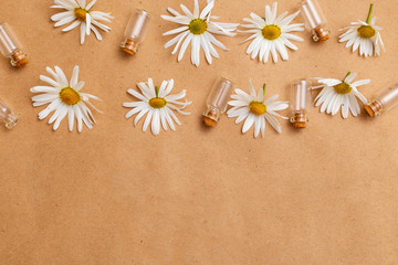 Fototapeta na wymiar Chamomile flowers and glass jars on craft paper. Copy space. Madern apothecary. Healthy lifestyle