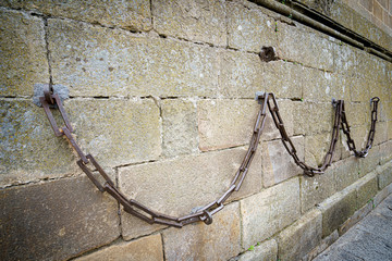 Heavy iron chain hung in the stone walls of the Cathedral of Plasencia, Spain. Is a Roman Catholic cathedral located in the town of Plasencia, Region of Extremadura, Spain. It is dedicated to the