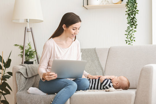 Woman working on laptop and taking care of her child