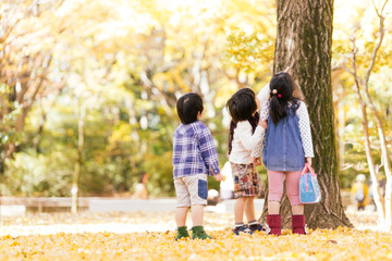 秋の公園で遊ぶ3人の子供たち