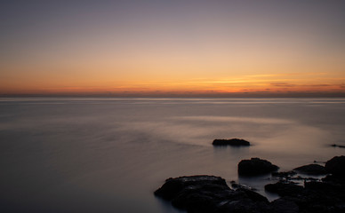 Fototapeta na wymiar Pre Sunrise near Cala Bona Mallorca with a flat sea giving a surreal feel to the early morning.