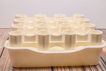 Fototapeta na wymiar White plastic drying rack for the bottles on the wooden table.