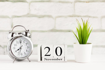 November 20 on a wooden calendar next to the alarm clock, the date of the autumn month