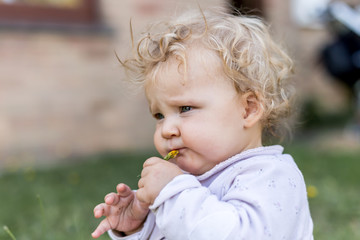 bébé fille mange une fleur