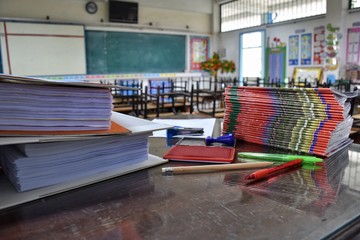 many documents and stationery on the teacher's desk in the classroom after school without students
