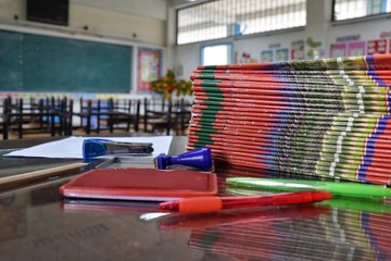 many documents and stationery on the teacher's desk in the classroom after school without students