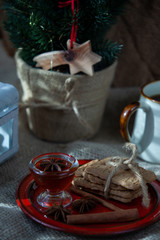 speculoos Christmas cookies on a red plate with star anise, honey and cinnamon, the effect of the film and tinting, soft focus and bokeh