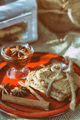 speculoos Christmas cookies on a red plate with star anise, honey and cinnamon, the effect of the film and tinting, soft focus and bokeh
