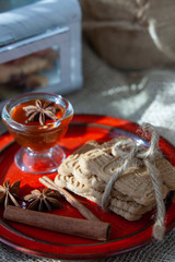 speculoos Christmas cookies on a red plate with star anise, honey and cinnamon, the effect of the film and tinting, soft focus and bokeh